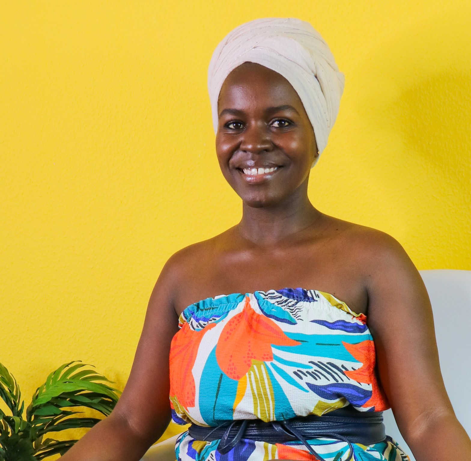WanjikuMwaura seated infront of a yellow background
